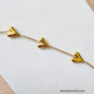 Close-up of three heart charms with smooth glossy finish and neat detailing.