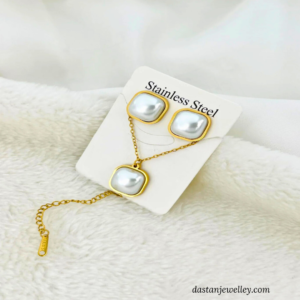 Matching stud earrings with white pearl-look stones and golden finish