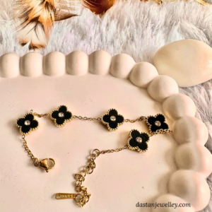Close-up of black clove charms with centre stone on golden chain